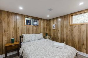 ein Schlafzimmer mit Bett und Holzwänden in der Unterkunft The River Nest in Bracebridge