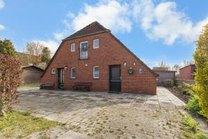 a brick house with a patio in front of it at Up Böhn in Krummhörn