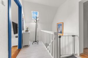 a room with a staircase with a tv and a blue door at Up Böhn in Krummhörn