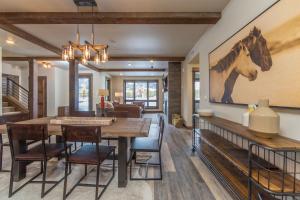 a dining room with a table and a horse painting on the wall at Mountain Lake Condo - Unit 102B in Big Sky