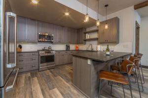 a kitchen with wooden cabinets and stainless steel appliances at Mountain Lake Condo - Unit 102B in Big Sky