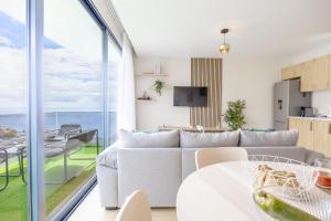 a living room with a couch and a table at Endless Horizon BY YOUR KEY MADEIRA in Santa Cruz