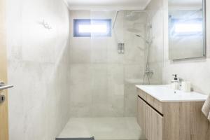 a white bathroom with a shower and a sink at Endless Horizon BY YOUR KEY MADEIRA in Santa Cruz +36 photos