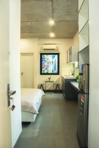a room with a bed and a kitchen with a tv at Fair Dinkum Stay District 1 in Ho Chi Minh City