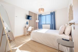 a bedroom with a white bed and a window at Endless Horizon BY YOUR KEY MADEIRA in Santa Cruz