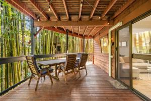a wooden deck with a table and chairs on it at The Bamboo Base at Buderim in Buderim