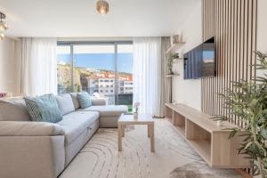 a living room with a couch and a tv at Endless Horizon BY YOUR KEY MADEIRA in Santa Cruz