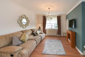 a living room with a couch and a television at Goldie Apartment 2BR flat in Dalry