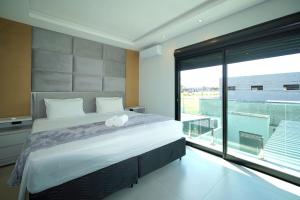 a bedroom with a large bed and a large window at Sobrado com Jacuzzi Aquecida 10 minutos Centro in Foz do Iguaçu