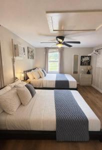 two beds in a bedroom with a ceiling fan at Western Studio in Houston