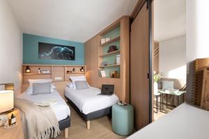a room with two beds and a laptop on it at Résidence Pierre & Vacances Capella in Avoriaz