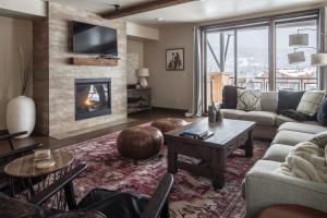 a living room with a couch and a fireplace at Mountain Lake Condo - Unit 401B in Big Sky