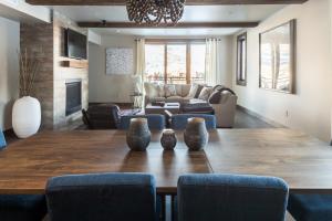 a living room with a large wooden table with vases on it at Mountain Lake Condo - Unit 401B in Big Sky +32 photos