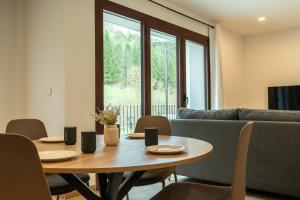 a dining room with a table and a couch at Silken Puerta de Irati in Ochagavía