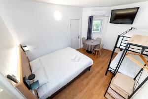 a bedroom with two bunk beds and a table at Kyriad Direct Macon Sud in Crêches-sur-Saône