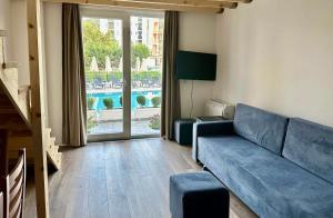 a living room with a couch and a large window at Hotel Iliria in Golem