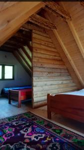 a room with two beds in a wooden attic at Peaceful Cottage in Bijelo Polje +3 photos