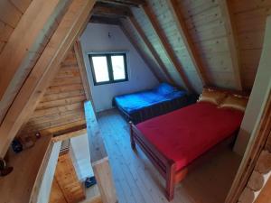 an attic room with two beds and a window at Peaceful Cottage in Bijelo Polje