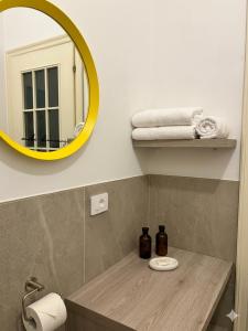 a bathroom with a yellow mirror and a sink at Feel B&B and more in Saluzzo +12 photos