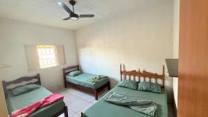 a bedroom with two beds and a ceiling fan at Recanto Jatobá - Delfinópolis in Delfinópolis