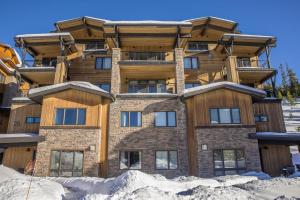 a large building with snow in front of it at Mountain Lake Condo - Unit 502B in Big Sky