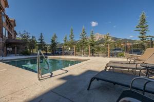 a swimming pool with two benches and a table at Mountain Lake Condo - Unit 502B in Big Sky