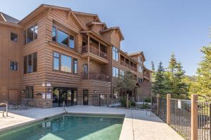 a house with a swimming pool in front of it at Mountain Lake Condo - Unit 502B in Big Sky
