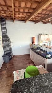 a kitchen with a green bowl on a table at Recanto Jatobá - Delfinópolis in Delfinópolis