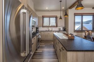 a large kitchen with a stainless steel refrigerator at Mountain Lake Condo - Unit 502B in Big Sky +34 photos