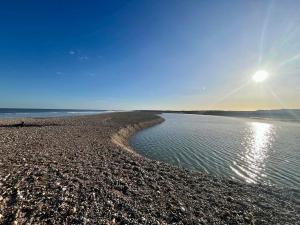 a beach with the sun rising over the water at Charming Chamber with spacious relaxing area in Pagham