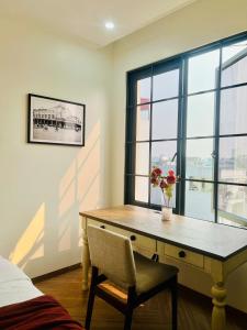 a bedroom with a desk with a vase of flowers on it at Khách sạn Solea VIỆT TRÌ in Việt Trì
