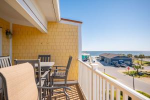 a balcony with a table and chairs and a view of the ocean at Sea Tales by Oak Island Accommodations in Oak Island