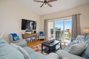 a living room with a couch and a tv at Sea Tales by Oak Island Accommodations in Oak Island