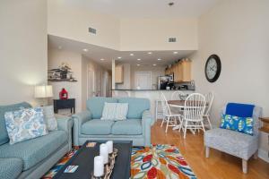 a living room with two blue couches and a kitchen at Sea Tales by Oak Island Accommodations in Oak Island +48 photos