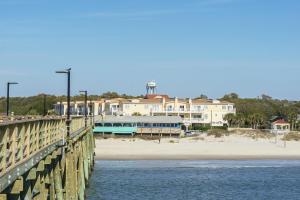 a bridge over the water next to a beach at Sea Tales by Oak Island Accommodations in Oak Island