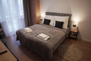 a bedroom with a large bed with two towels on it at Willa Nowa 33 in Wisła