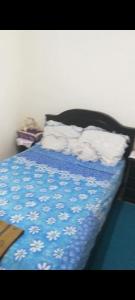 a bed with a blue comforter and white sheets at سيدي رحال الشاطئ in Sidi Rahal