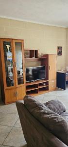 a living room with a tv and a couch at Quiet, spacious 3 bedroom 2 bathroom apartment in Għajnsielem