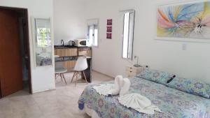a bedroom with a bed and a kitchen with a table at Refugio de Luna Termal in Termas de Río Hondo +11 photos