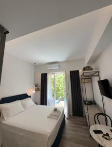 a bedroom with a large white bed and a window at MUSES LUXURY SUITES in Corfu