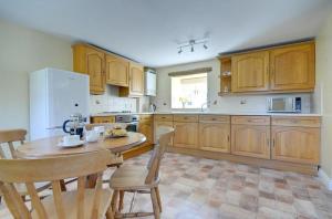 a kitchen with wooden cabinets and a table and chairs at 2 Bed in Pickering oc-y012 in Pickering