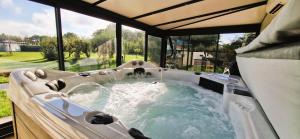 a jacuzzi tub in a room with windows at Fleur De Cerisier Vendée in Challans