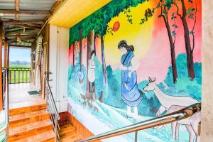 a mural on the wall of a hallway in a house at Super Hotel O Chilapata Forest Formerly Moner Manush Homestay in Uttar Simlabari +45 photos