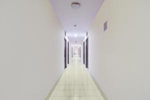 an empty hallway with white walls and white floors at Hotel O Paradise Circle in Hyderabad