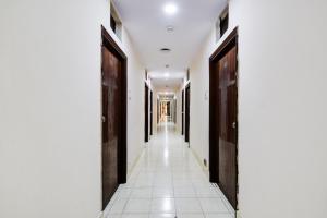 a corridor of a building with doors and tile floors at Hotel O Paradise Circle in Hyderabad +32 photos