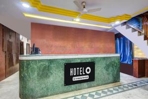 a hotel reception counter in a room with a ceiling fan at Hotel O Paradise Circle in Hyderabad
