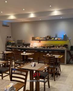 a restaurant with wooden tables and chairs and a counter at Jandira Premiêr Hotel in Jandira