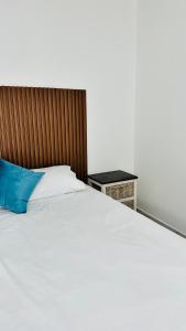 a large white bed with a blue pillow on it at Spadade View in Roodepoort