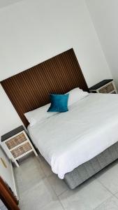 a bedroom with a large white bed with a wooden headboard at Spadade View in Roodepoort +9 photos