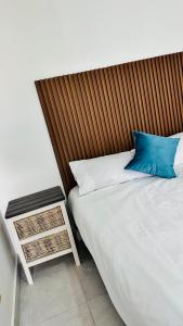 a bed with a wooden headboard and a blue pillow at Spadade View in Roodepoort
